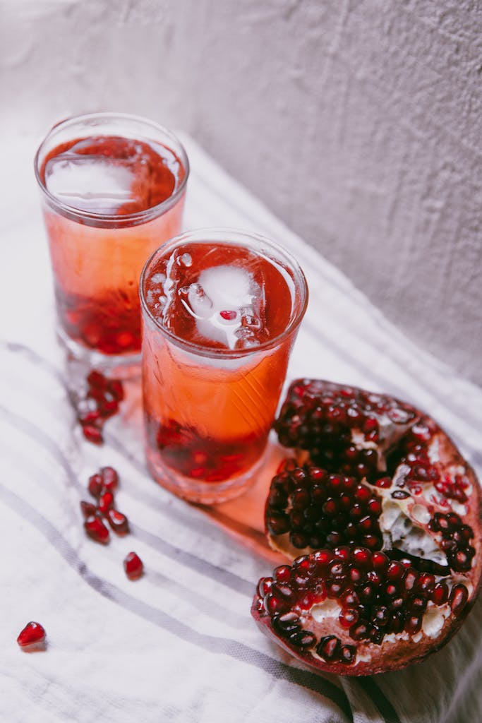 Pomegranate juice and pomegranate slices on a white cloth